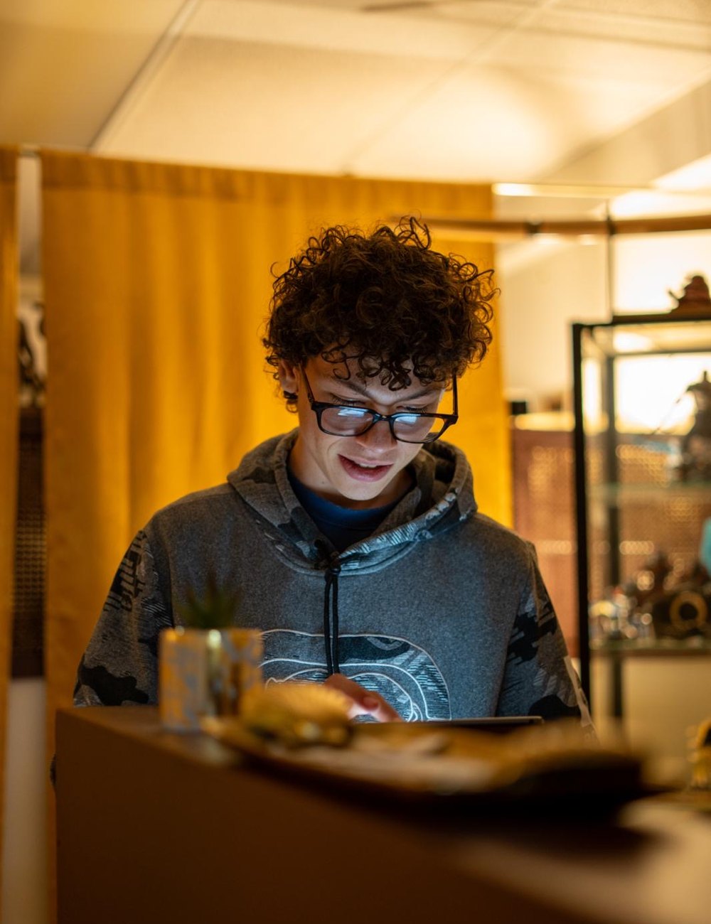 Israel Crespo at the Golden Ink counter, reviewing a design on a tablet