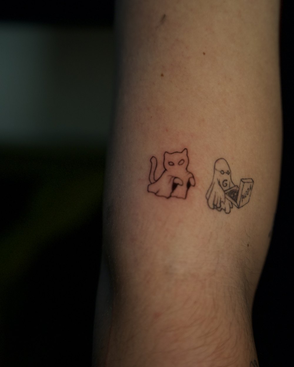 Small cat and ghost characters tattooed on the inner wrist, by Israel Crespo